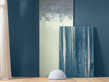  Ein Raum mit einem blauen Anstrich an der Wand. An der Wand befindet sich ein vertikales Gemälde in sanften Blau- und Grautönen. 