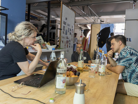 Eine Gruppe von drei Personen sitzt an einem Tisch und diskutieren über ein Thema.