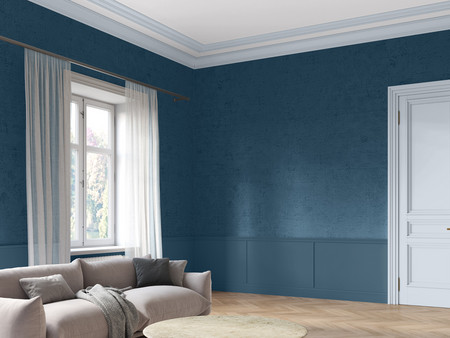Ein stilvoll eingerichteter Raum mit blauen Wänden und Holzfußboden. An der linken Seite des Raumes steht ein helles, modernes Sofa mit Kissen. Große, helle Vorhänge hängen vor einem Fenster, das Tageslicht hereinlässt.